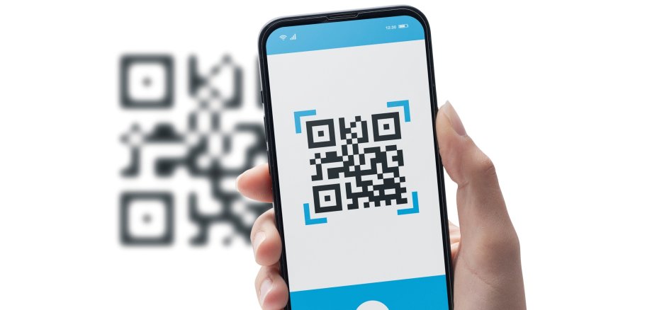 Frau, die einen QR-Code mit dem Smartphone scannt