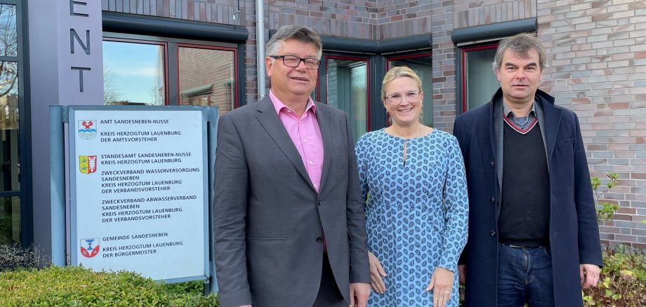 Im Bild zu sehen sind von links nach rechts, der Amtsvorsteher Ulrich Hardtke, die leitende Verwaltungsbeamtin Tina Knuth und der Landtagsabgeordnete  Oliver Brandt vor dem Regionalzentrum in Sandesneben.