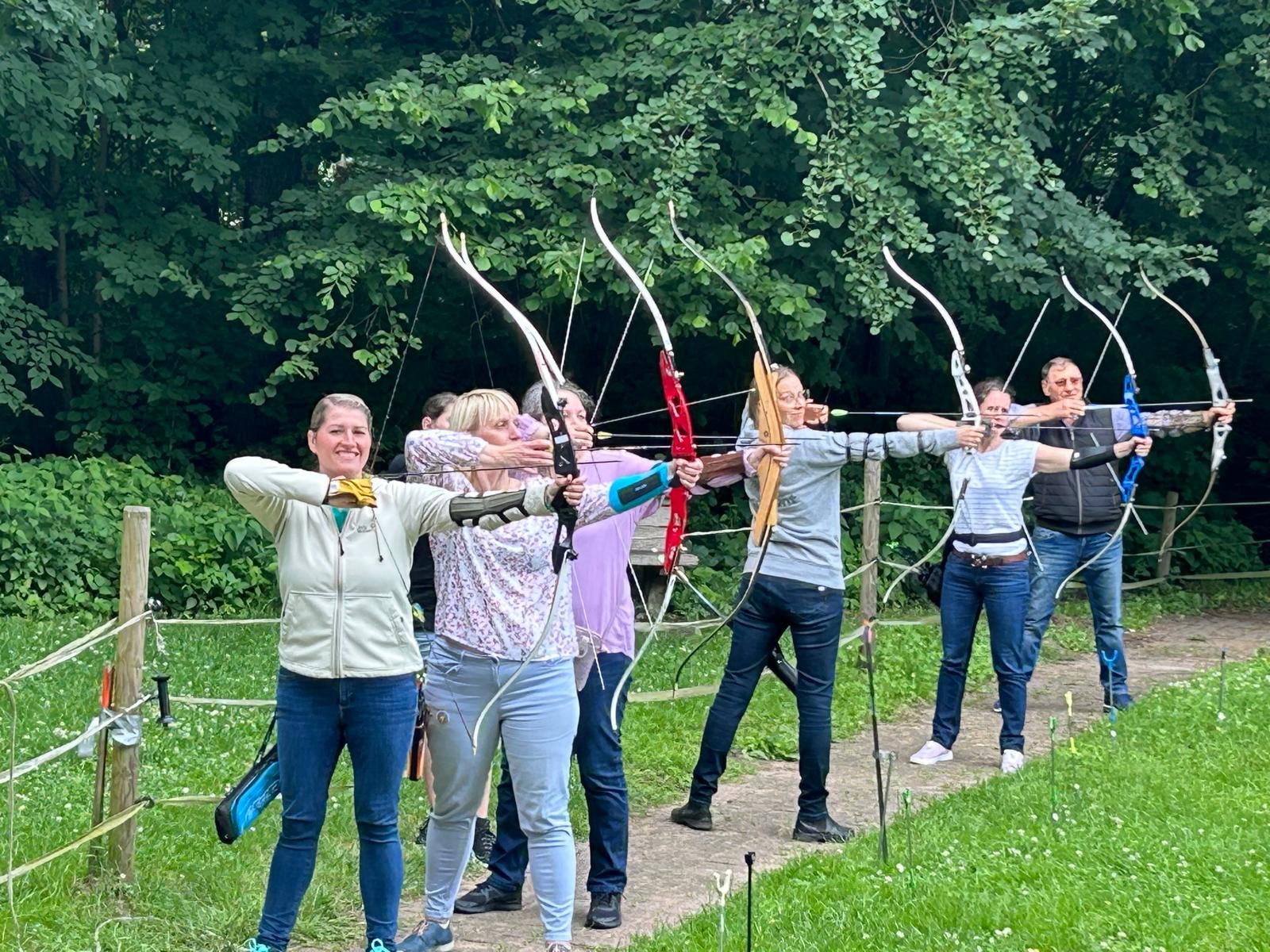 6 Personen des Patenstammtisches die in einer Reihe mit einem gespannten Bogen stehen.
