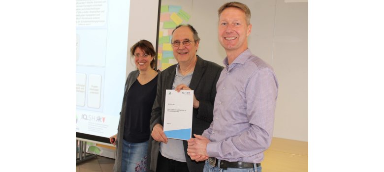Schulleiter Dr. Jan Rüder (Mitte) erhält von Julia Iser und Torsten Hardt vom IQSH (Institut für Qualitätsentwicklung an Schulen Schleswig-Holstein) das Schulfeedback für die Gemeinschaftsschule Sandesneben.