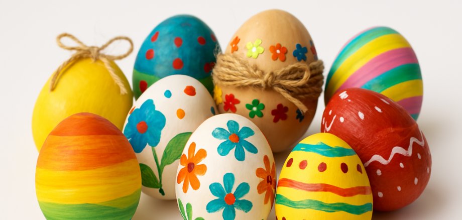 Acht kunstvoll verzierte Ostereier liegen auf weißem Hintergrund. Jedes Ei ist individuell gestaltet – mit bunten Farben, Mustern, Glitzer oder Naturmaterialien – und zeigt die kreative Vielfalt traditioneller Osterdekoration.