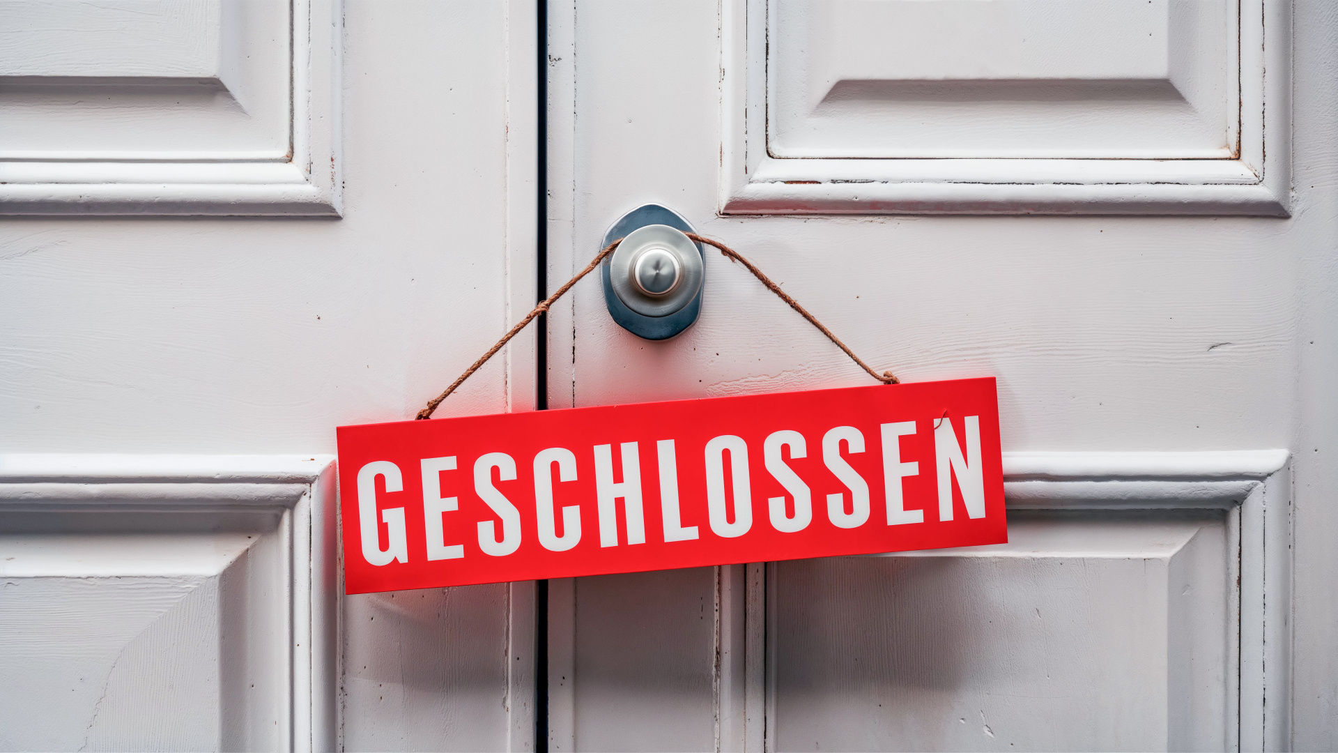 °Geschlossen“ Schild an einer weißen Tür °Geschlossen“ Schild an einer weißen Tür