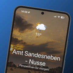 Smartphone mit geöffneter FRED-App zeigt Startbildschirm des Amtes Sandesneben-Nusse mit Wetteranzeige und Symbolen für Rathaus, Bildung, Vereine und Veranstaltungen.