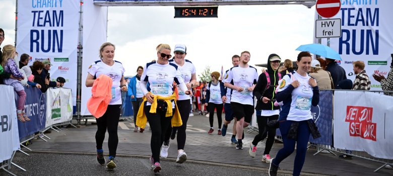 Leichtathletik eilnehmende des Teams „Die galoppierenden Amtsschimmel“ starten beim HafenCityRun 2025 in Hamburg unter dem Startbogen des Charity-Laufs.