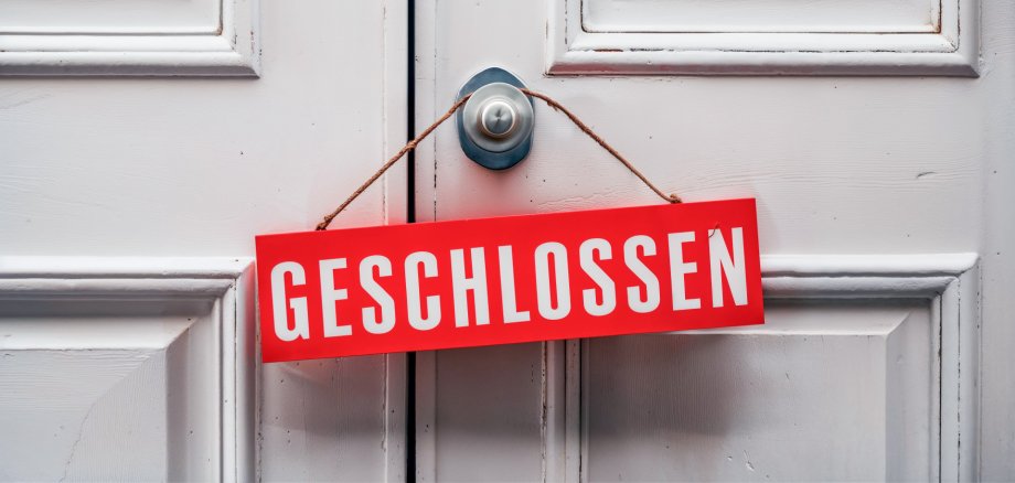 °Geschlossen“ Schild an einer weißen Tür