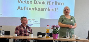 Referentin des Pflegestützpunktes spricht vor den Gästen. Im Hintergrund ist die Abschlussfolie der Präsentation zu sehen.