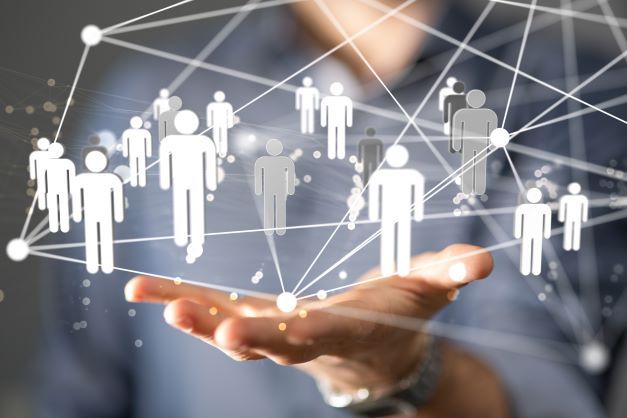 Hologramm mit Personenabbildungen die jeweils durch weiße Linien miteinander verbunden sind. Darunter eine Hand über der die Abbildungen schweben.