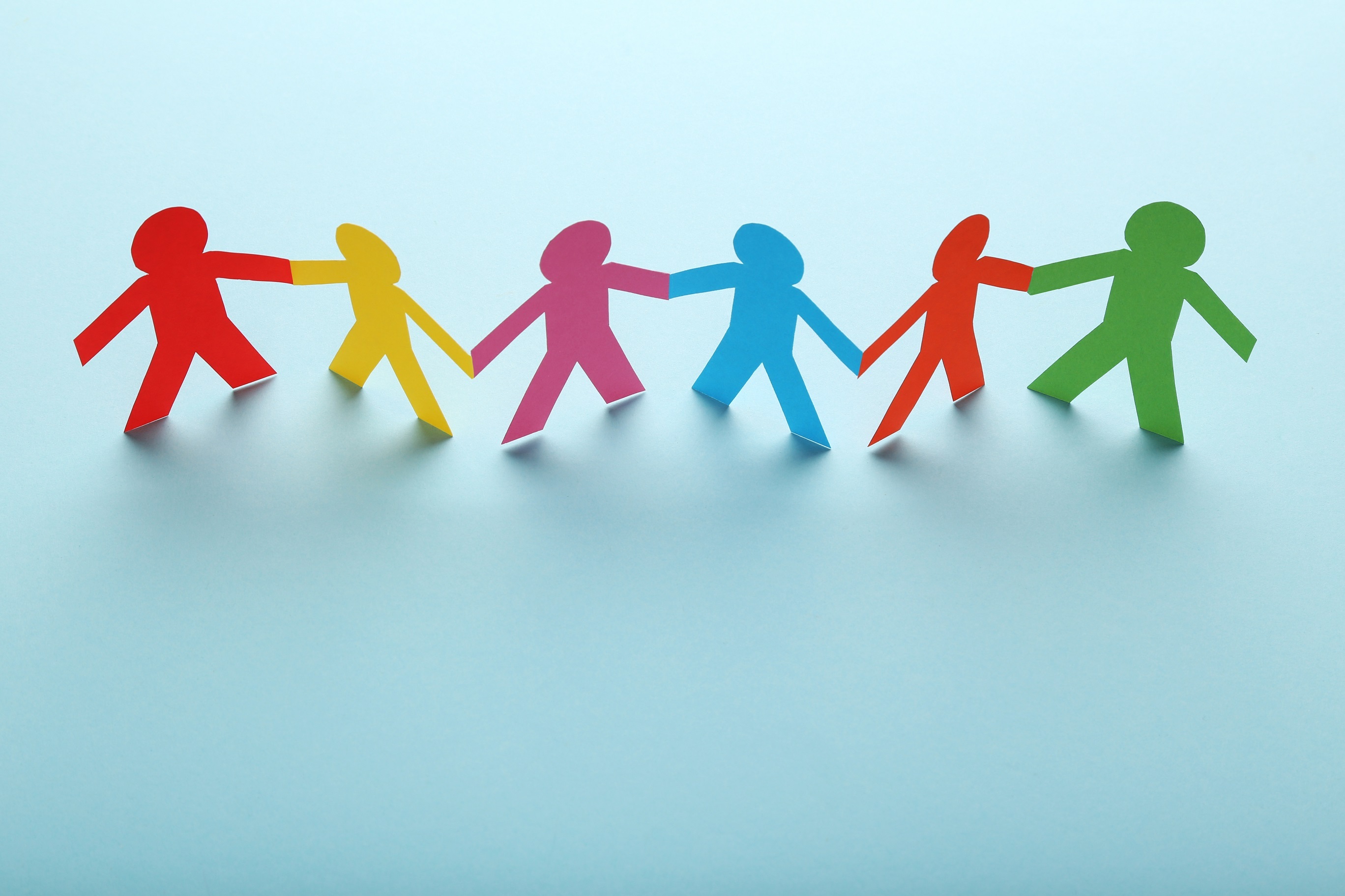 Farbige Papierpersonen auf blauem Hintergrund