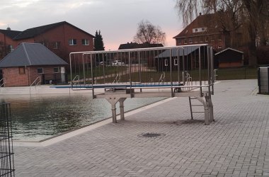 Schwimmbecken im Freibad Steinhorst mit Sprungturm und gepflasterten Flächen.