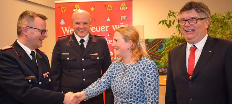 Die Leitende Verwaltungsbeamtin im Amt Sandesneben-Nusse Tina Knuth gratuliert Kim Sascha Steingrube zur Wiederwahl als stellvertretender Amtswehrführer. Zweiter von links der ebenfalls wiedergewählte stellvertretende Amtswehrführer Karl Björn Petersen, rechts Amtsvorsteher Ulrich Hardtke.